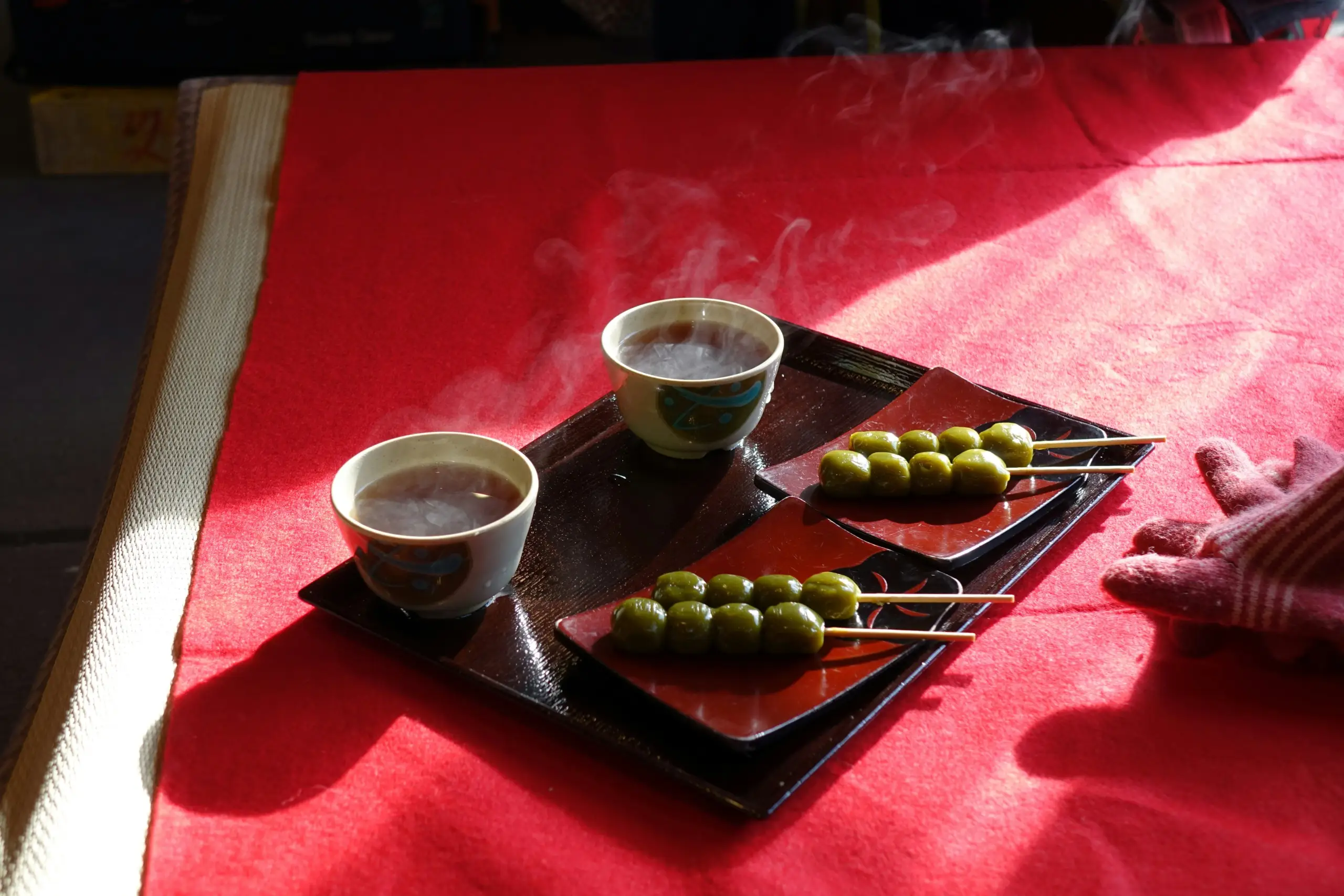 فنجانا قهوة ساخنة على صينية مع زيتون—أجواء تذوق مستوحاة من ترند القهوة بزيت الزيتون.