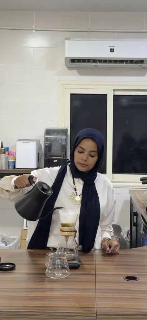 سيدة تحضّر قهوة ترشيح يدوي بكيماكس—خطوات تساعد على تقليل الأعراض الصحية والقهوة مثل الحموضة والتوتر عند اختيار التحضير الصحيح.